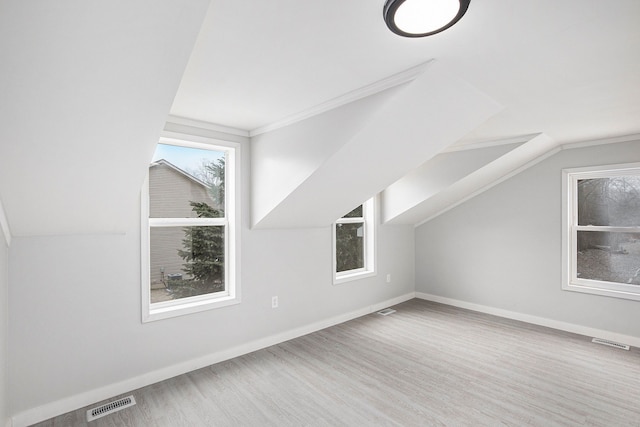 additional living space with light hardwood / wood-style floors and vaulted ceiling