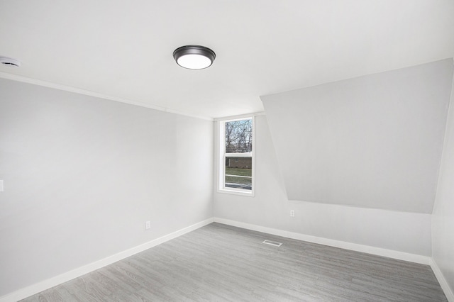 unfurnished room with wood finished floors, visible vents, and baseboards