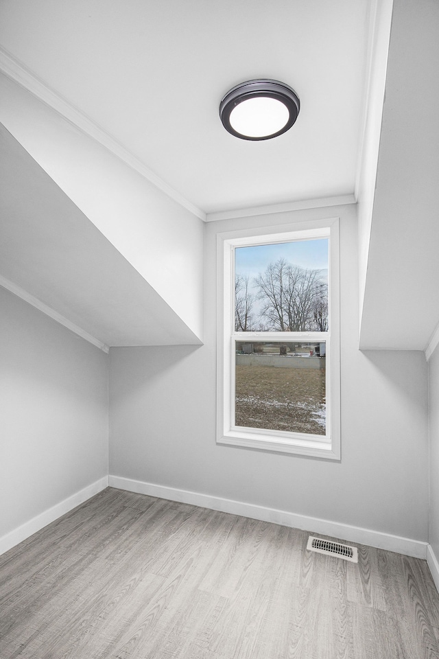 additional living space featuring visible vents, baseboards, and wood finished floors