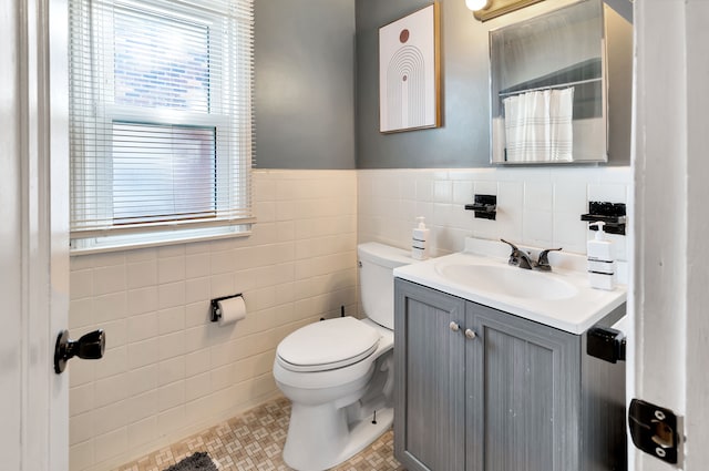 bathroom featuring toilet, tile walls, tile patterned floors, and vanity