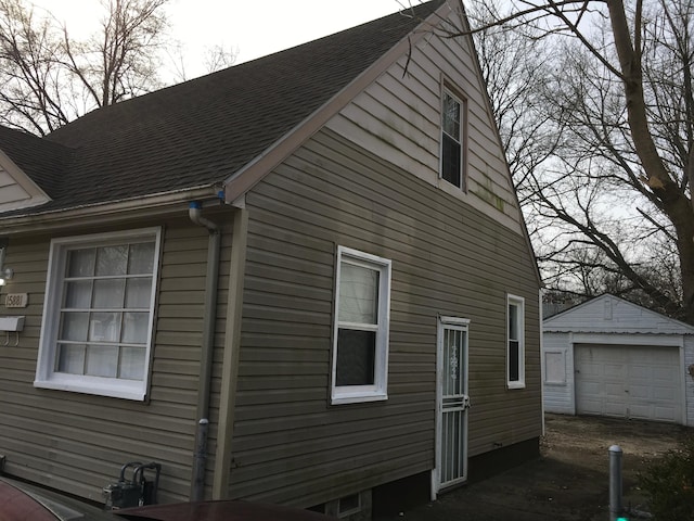 view of home's exterior featuring a garage and an outbuilding