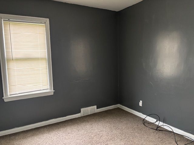 carpeted empty room with baseboards