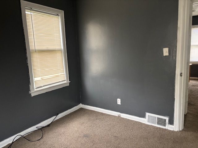 carpeted spare room with baseboards