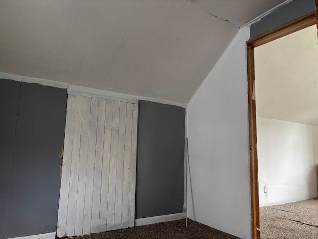 bonus room with lofted ceiling and carpet flooring