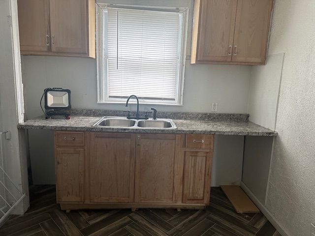 kitchen featuring a sink and a textured wall