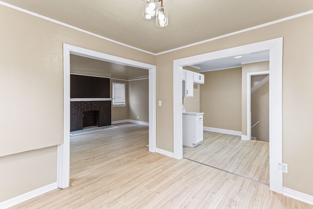 interior space featuring a fireplace, light hardwood / wood-style floors, and ornamental molding