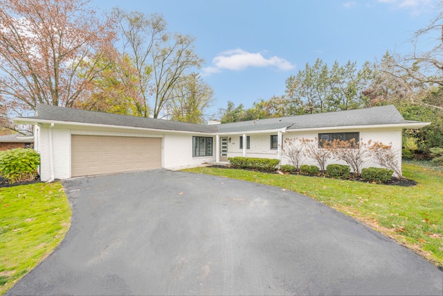 single story home with a garage and a front lawn