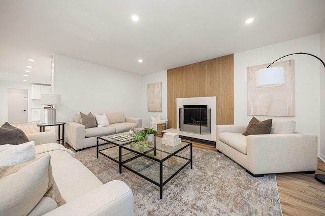 living room featuring light wood-type flooring and a large fireplace