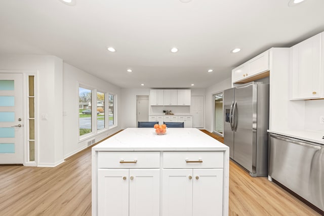 kitchen with light hardwood / wood-style floors, white cabinetry, a center island, and stainless steel appliances