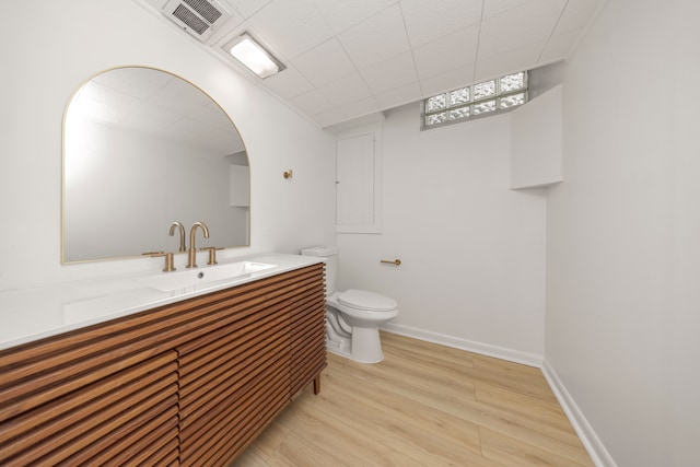 bathroom with wood-type flooring, toilet, and vanity