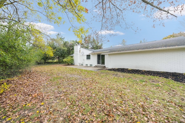 rear view of property with a patio and a lawn