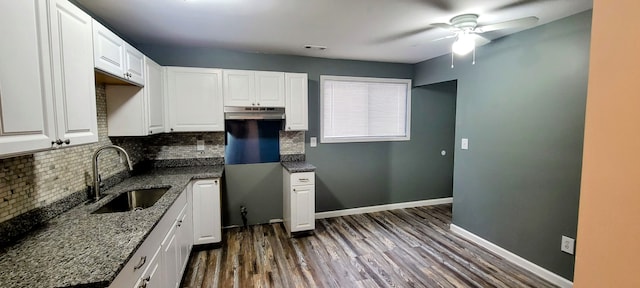 kitchen with tasteful backsplash, visible vents, baseboards, white cabinetry, and a sink