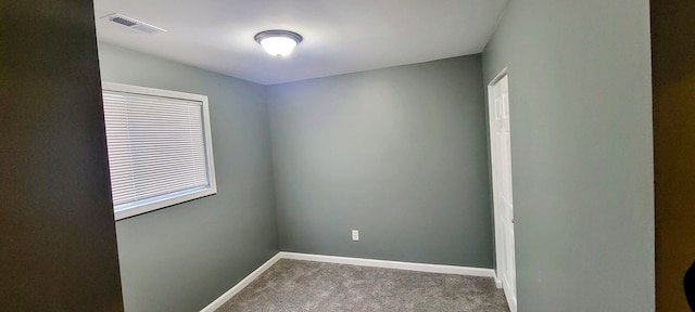 spare room with carpet, visible vents, and baseboards