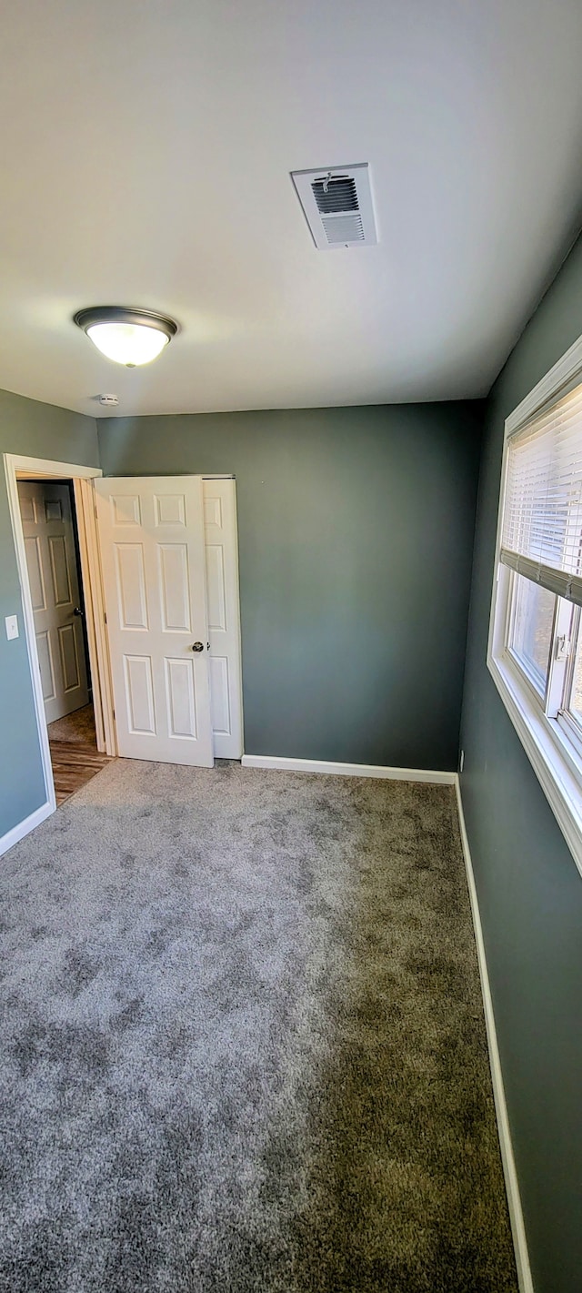 unfurnished bedroom with visible vents, baseboards, and carpet