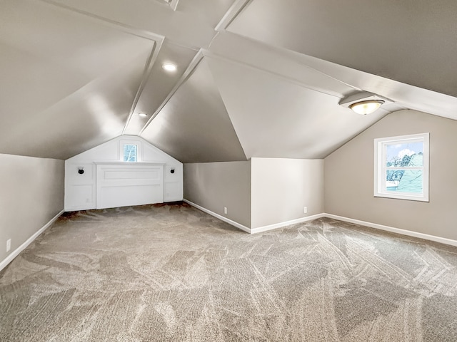 bonus room featuring vaulted ceiling, carpet floors, baseboards, and a healthy amount of sunlight