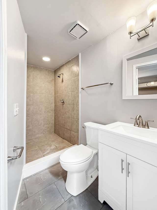 full bathroom featuring visible vents, tiled shower, vanity, and toilet