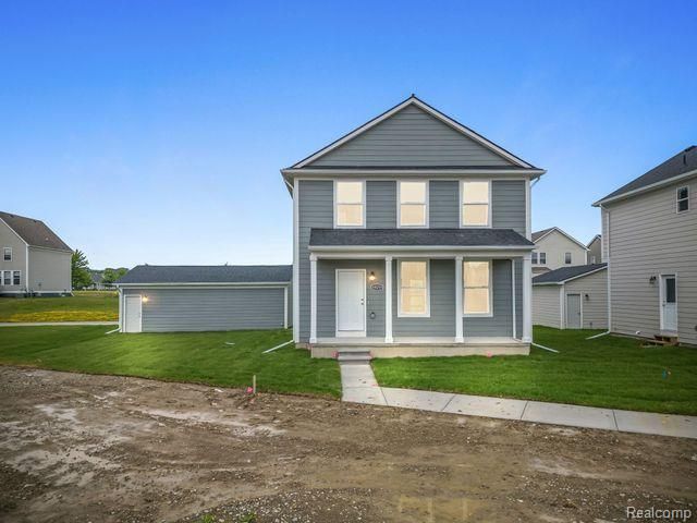 front facade with covered porch and a front lawn