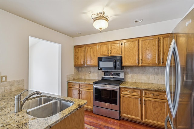 kitchen with light stone countertops, sink, appliances with stainless steel finishes, and tasteful backsplash