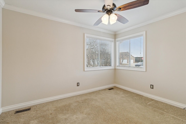 empty room with ceiling fan, crown molding, and light carpet