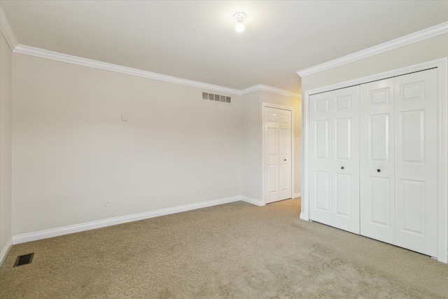 unfurnished bedroom featuring a closet, crown molding, and light carpet