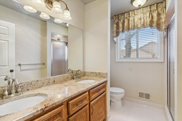 bathroom featuring tile patterned floors, an enclosed shower, vanity, and toilet