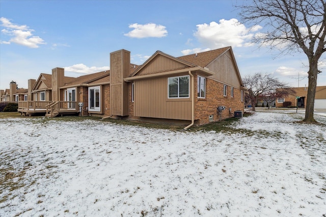 snow covered property with a deck