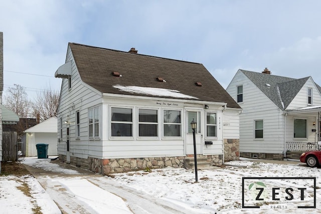 snow covered house featuring a garage