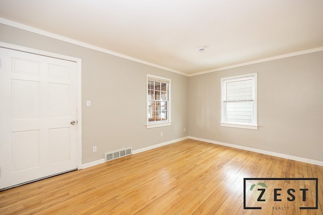 empty room featuring ornamental molding and light hardwood / wood-style floors