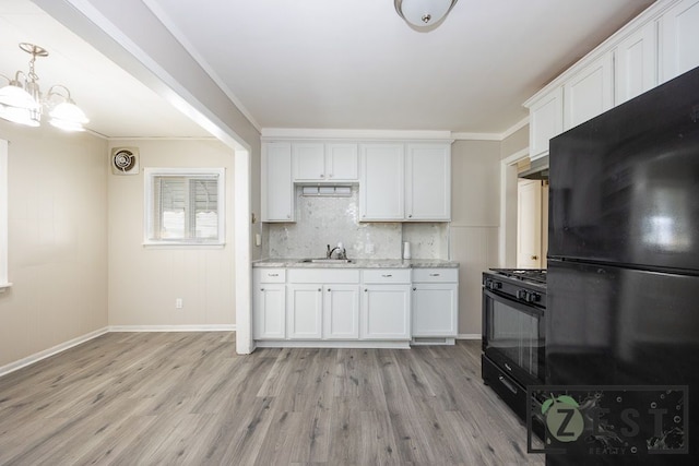 kitchen featuring sink, ornamental molding, black appliances, and white cabinets