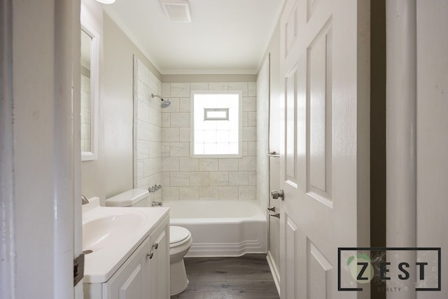 full bathroom with vanity, hardwood / wood-style floors, tiled shower / bath combo, and toilet