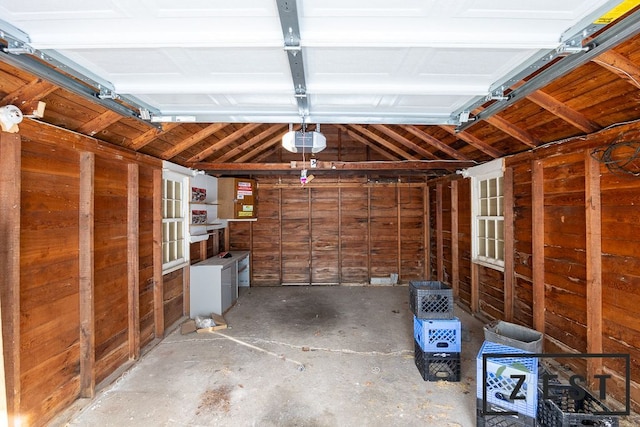 garage featuring a garage door opener and wood walls