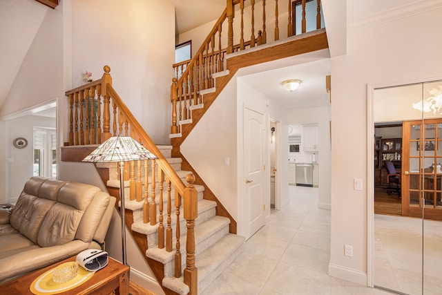 stairs featuring high vaulted ceiling and tile patterned floors