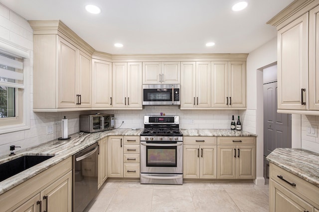 kitchen with light stone counters, tasteful backsplash, and appliances with stainless steel finishes