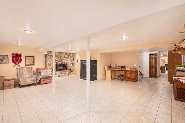 basement with light tile patterned floors and a stone fireplace