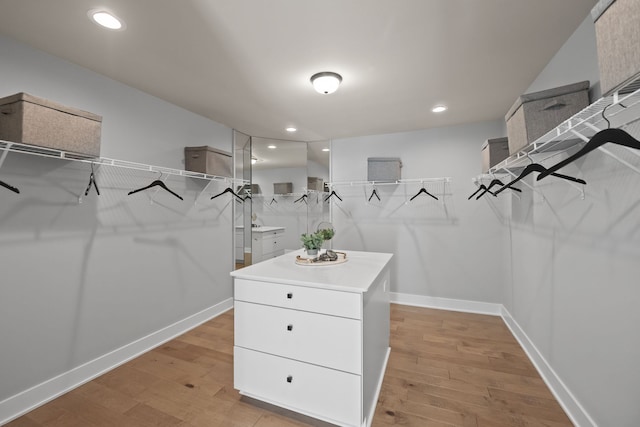 walk in closet with light hardwood / wood-style flooring