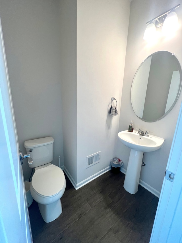 bathroom featuring wood-type flooring, sink, and toilet