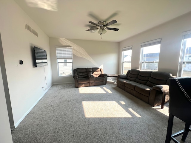 living room with ceiling fan, a wealth of natural light, and carpet floors