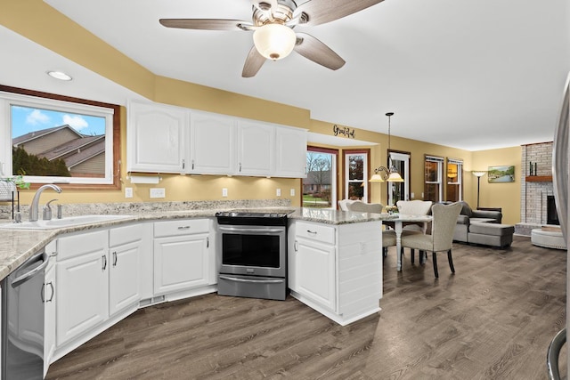 kitchen with sink, decorative light fixtures, white cabinets, and appliances with stainless steel finishes