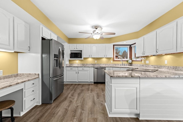 kitchen with sink, ceiling fan, appliances with stainless steel finishes, white cabinetry, and light stone counters