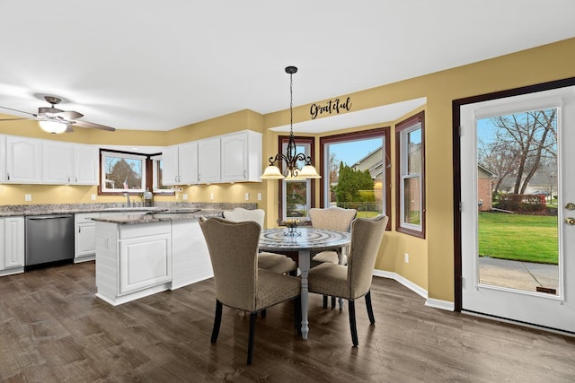 dining space with dark wood-type flooring and ceiling fan with notable chandelier