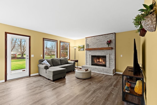 living room with hardwood / wood-style flooring and a brick fireplace