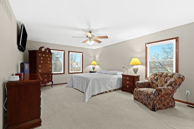 carpeted bedroom with ceiling fan and multiple windows