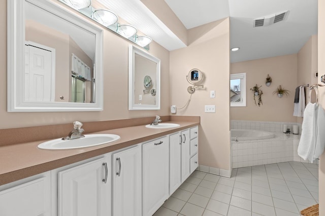 bathroom with vanity, tiled bath, and tile patterned floors