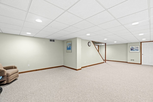 basement with a paneled ceiling and carpet flooring