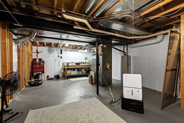 basement featuring heating unit, water heater, and a workshop area