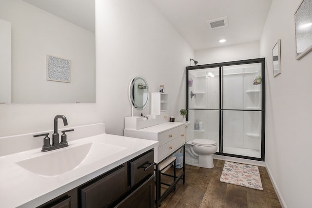 bathroom with vanity, toilet, a shower with door, and wood-type flooring