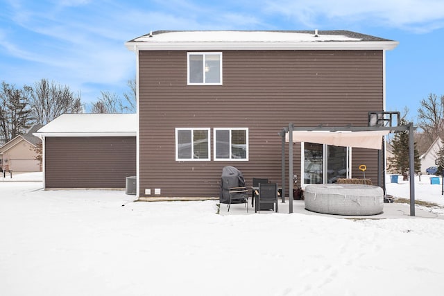 snow covered property featuring central AC