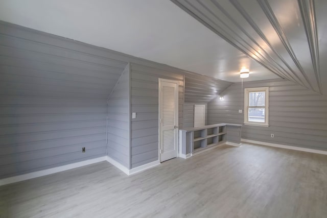 bonus room with light hardwood / wood-style floors and vaulted ceiling