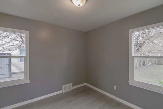 unfurnished room with plenty of natural light and wood-type flooring