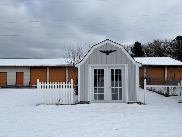 snow covered structure with fence